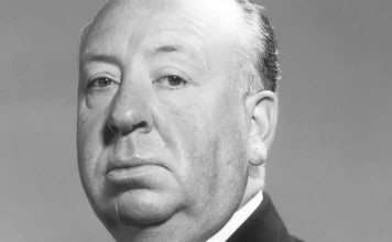 A black and white studio portrait of Alfred Hitchcock