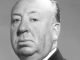 A black and white studio portrait of Alfred Hitchcock