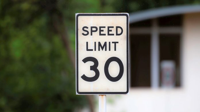 speed limit sign post on a roadside close up