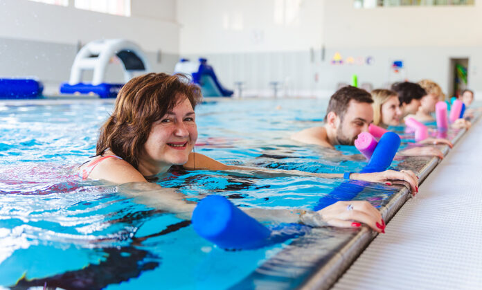 Fitness aqua aerobic class swimming AdobeStock_2044658355 Aquatic fitness swimming