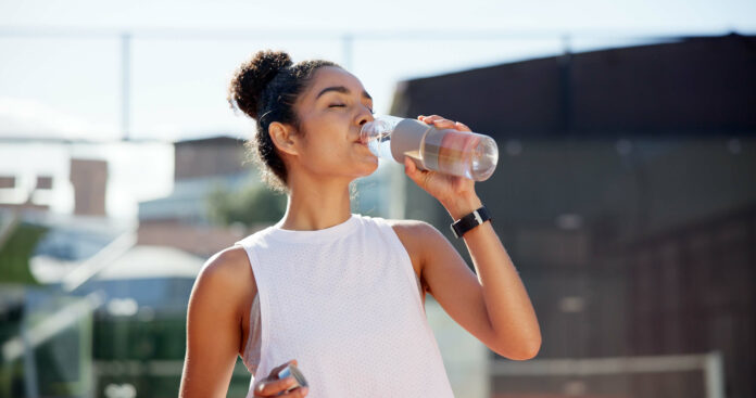 Fitness drinking water AdobeStock_1290138001 Woman drinking water hydration